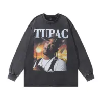 Чорний оверсайз лонгслів з принтом Tupac Shakur на фоні заходу сонця, розкладений на білому тлі.